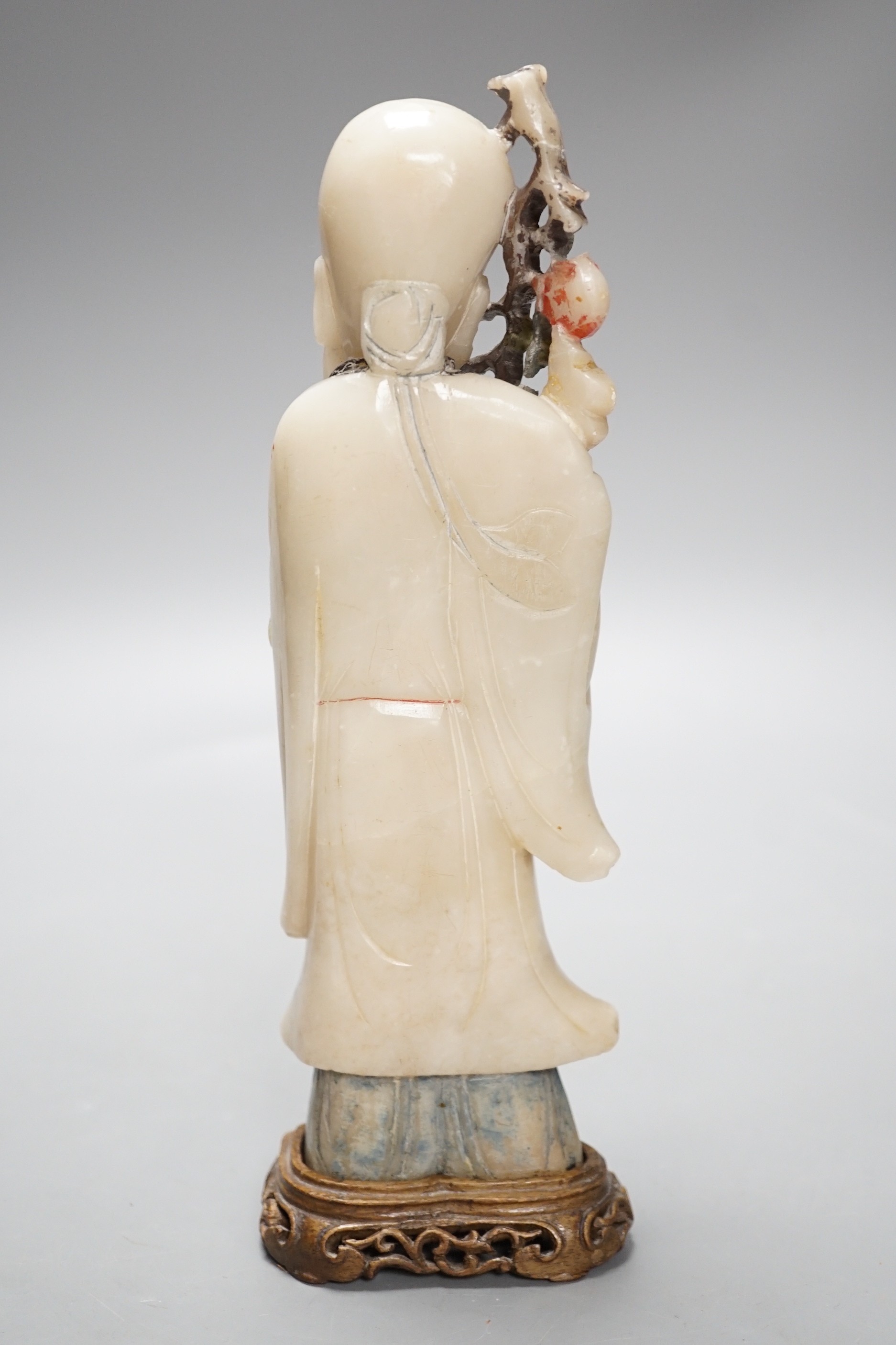 A 18th century Chinese carved soapstone figure of Shao Lou on carved hardwood stand. 24cm high.